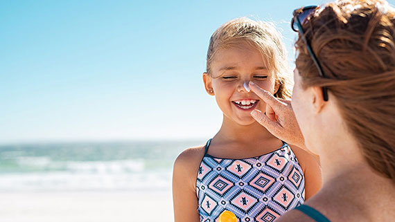 A woman applying sunscreen to leg
