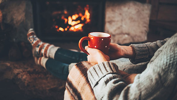 A couple sitting in front of fireplace talking