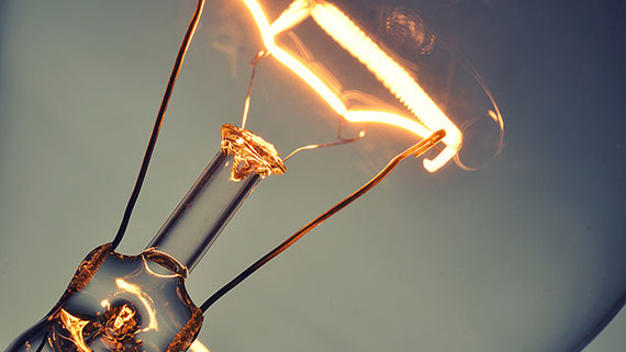 A lone lit lightbulb among a row of lightbulbs