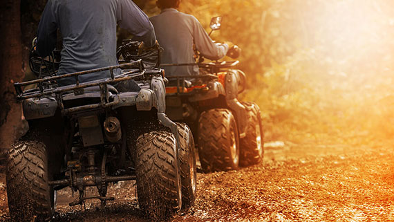 An ATV rider navigating over sandy dunes