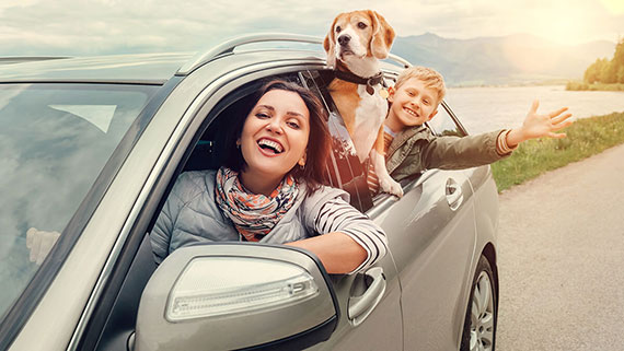 A happy family looking out back of car