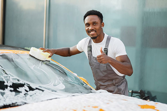 A young man washing his car