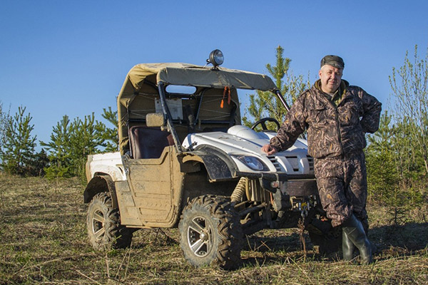 A hunter posing in front of an UTV
